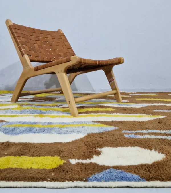 Zola handmade Beni Ourain wool rug with an abstract design of vertical white, blue, and green shapes on a brown background in room