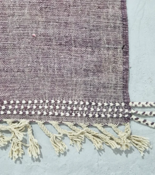 Detailed View of Zola handmade Kilim flatweave wool rug with a purple background and white and yellow geometric shapes