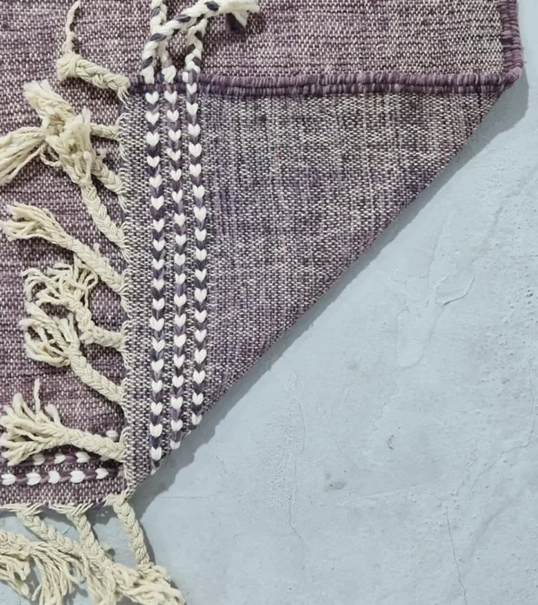 Detailed View of Zola handmade Kilim flatweave wool rug with a purple background and white and yellow geometric shapes