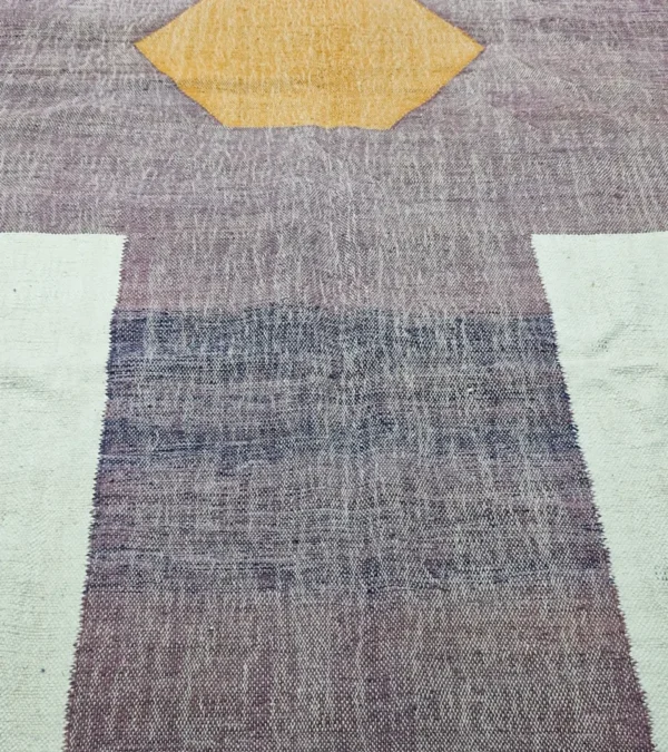 Detailed View of Zola handmade Kilim flatweave wool rug with a purple background and white and yellow geometric shapes