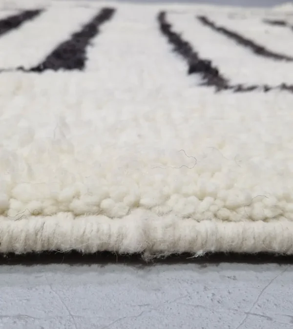 Zoomed In View of Zola handmade Beni Ourain wool rug with a minimalist design of bold black lines on an ivory background