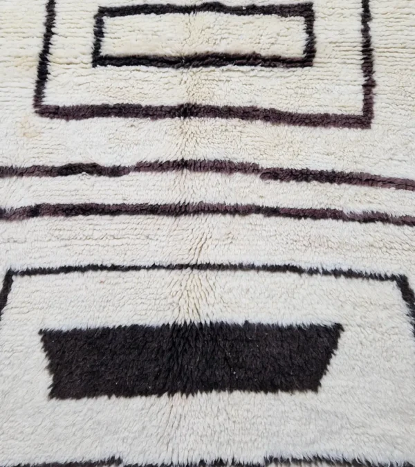 Detailed View of Zola handmade Beni Ourain wool rug with a minimalist design of bold black lines on an ivory background