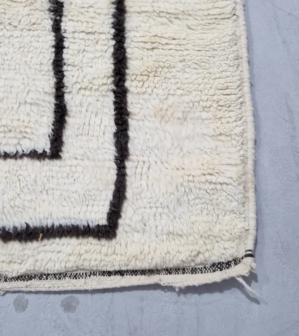 Detailed View of Zola handmade Beni Ourain wool rug with a minimalist design of bold black lines on an ivory background