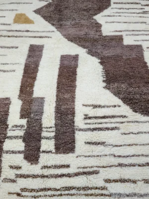 Detailed View of Zola handmade Azilal wool rug with a textured abstract striped design in brown, off-white, light blue, and tan