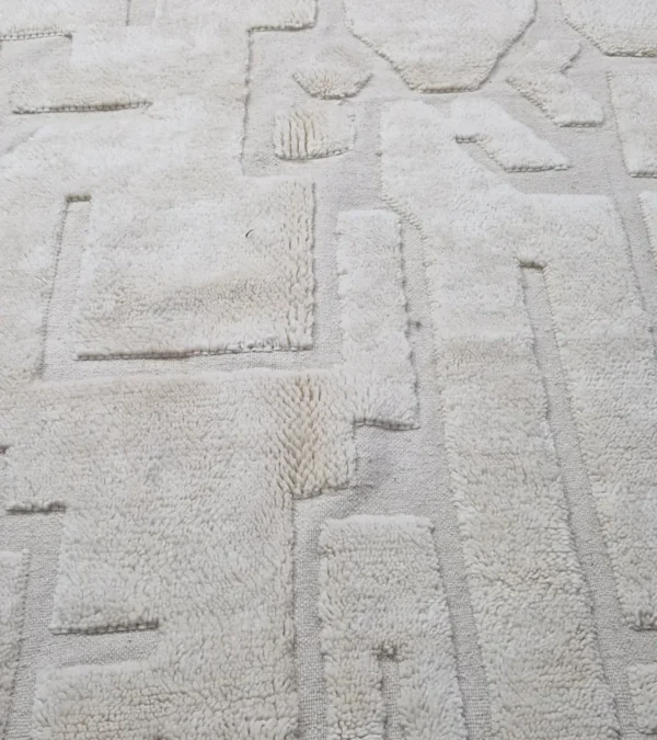 Detailed View of Zuri handmade Beni Ourain wool rug with an abstract high-low pile design on a neutral ivory background