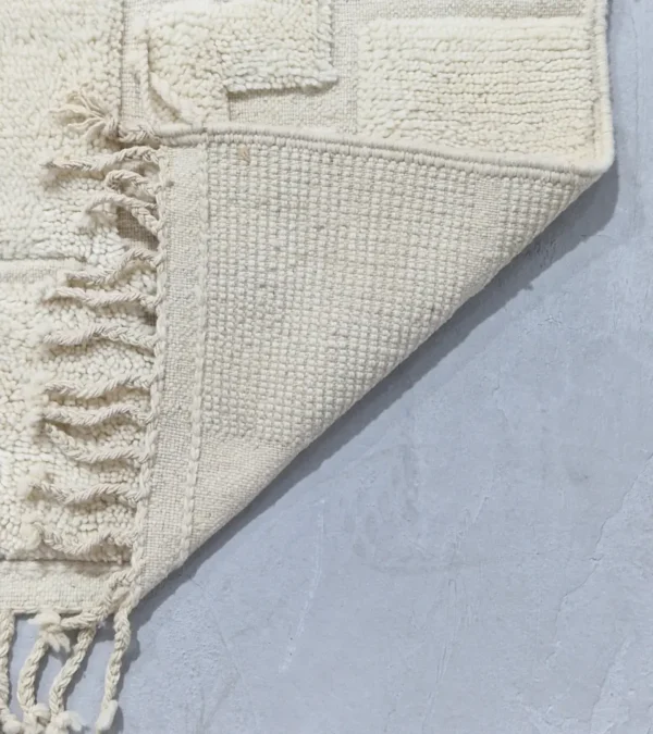 Detailed View of Zuri handmade Beni Ourain wool rug with an abstract high-low pile design on a neutral ivory background