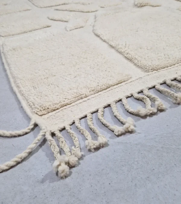 Detailed View of Zuri handmade Beni Ourain wool rug with an abstract high-low pile design on a neutral ivory background