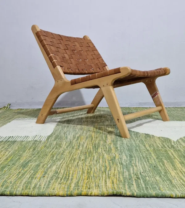 Zuri handmade Kilim flatweave rug with a minimalist textured design and geometric shapes on a green background in room