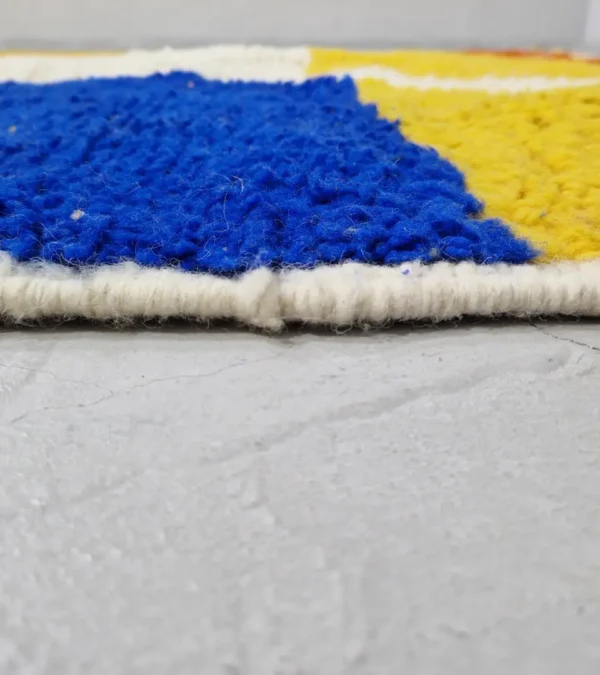 zoomed in view of Abstract color block Moroccan wool rug with yellow, blue, orange, and ivory panels