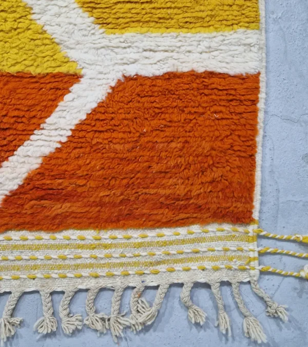 detailed view of Abstract color block Moroccan wool rug with yellow, blue, orange, and ivory panels
