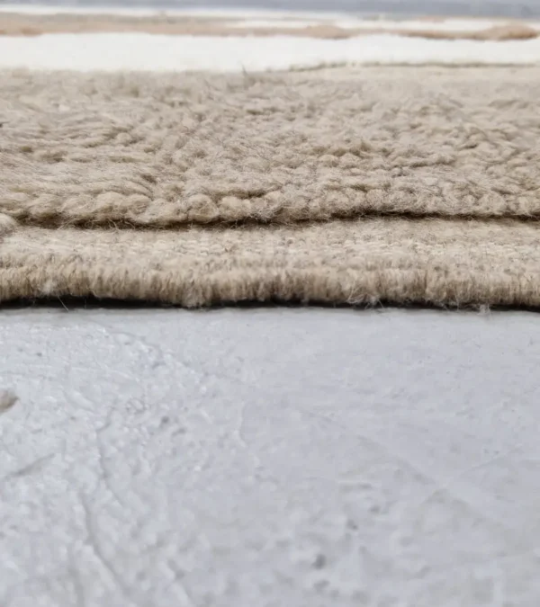 zoomed in view of Earth tone striped Moroccan rug in beige, taupe, and ivory
