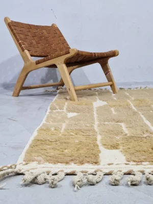 Golden brown geometric Moroccan rug with creamy off-white wool background in room