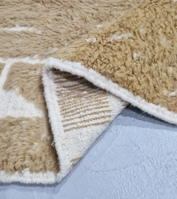 detailed view of Golden brown geometric Moroccan rug with creamy off-white wool background