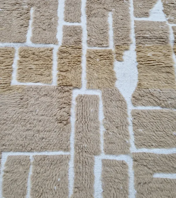 detailed view of Golden brown geometric Moroccan rug with creamy off-white wool background