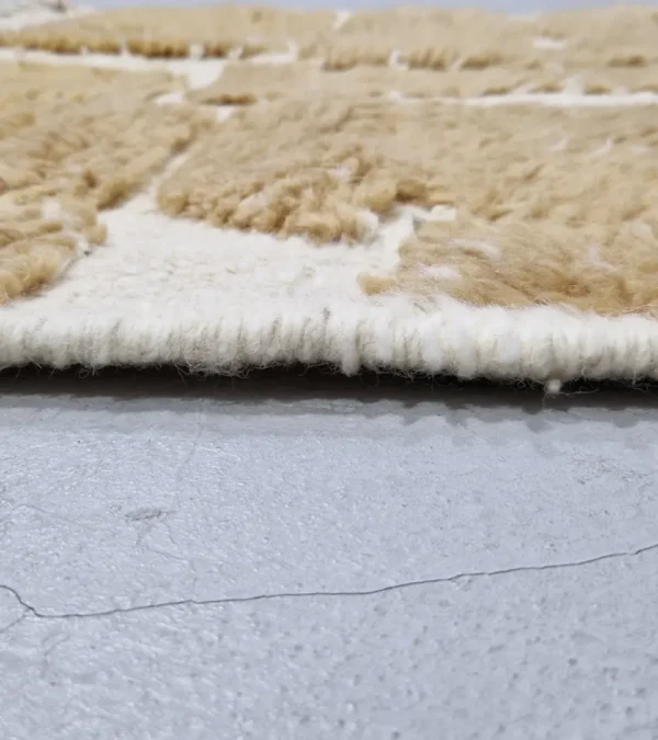 zoomed in view of Golden brown geometric Moroccan rug with creamy off-white wool background