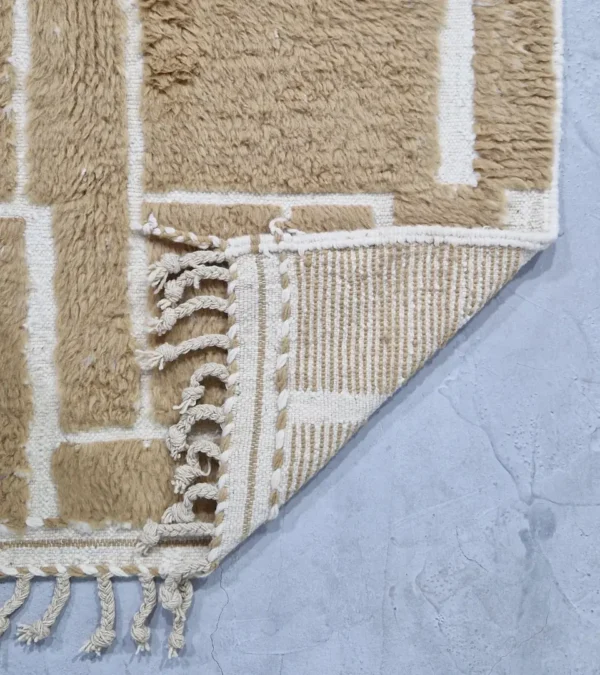 detailed view of Golden brown geometric Moroccan rug with creamy off-white wool background
