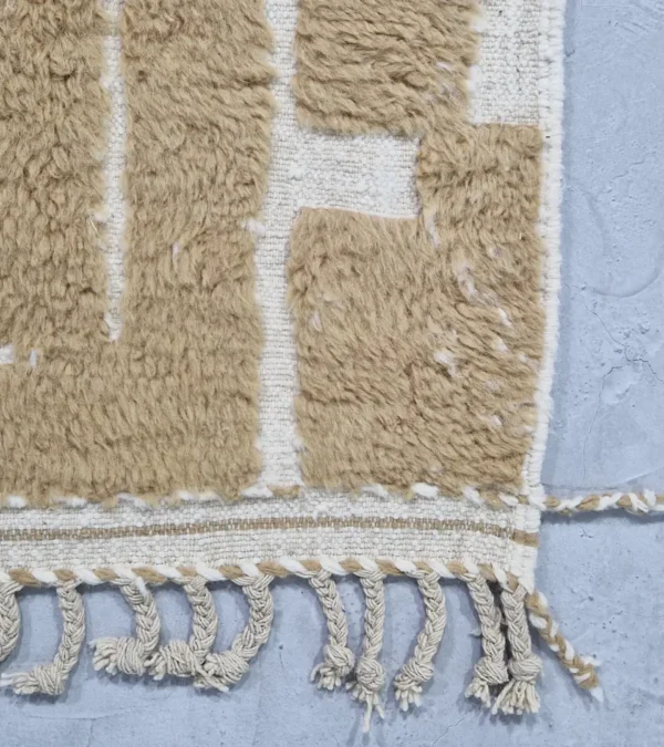 detailed view of Golden brown geometric Moroccan rug with creamy off-white wool background