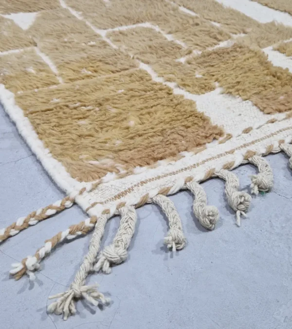 detailed view of Golden brown geometric Moroccan rug with creamy off-white wool background