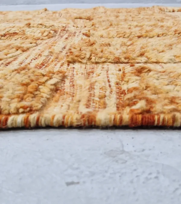 zoomed in view of Goldenrod wool rug with plush high-pile texture and beige geometric grid pattern