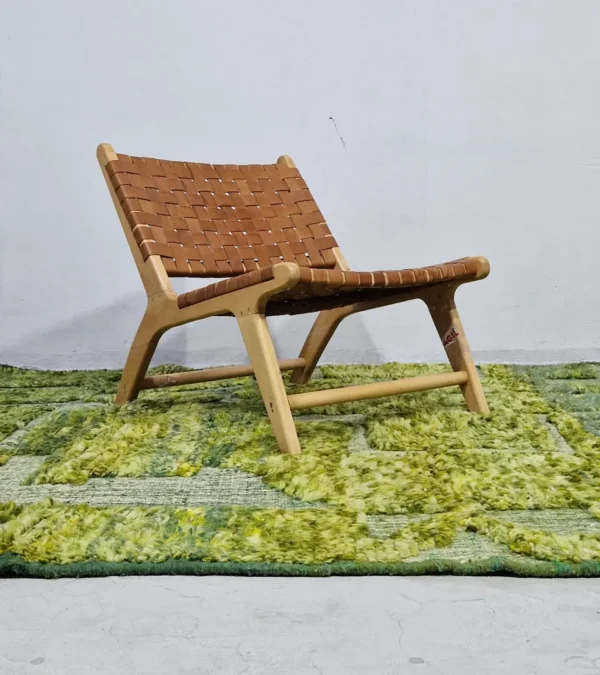 Hand-knotted Moroccan rug with sculpted high-pile texture, variegated green tones, and dual-pattern design with tassels in room