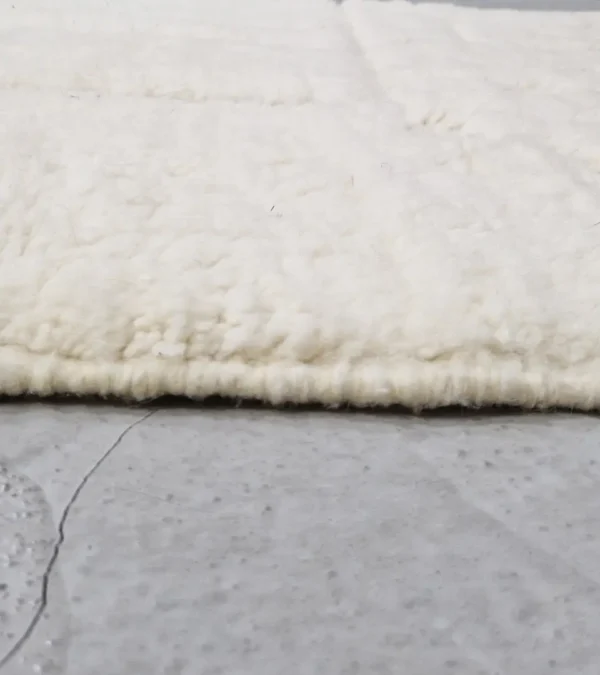 zoomed in view Handcrafted ivory Moroccan rug with sculpted high-low grid design and fringe tassels