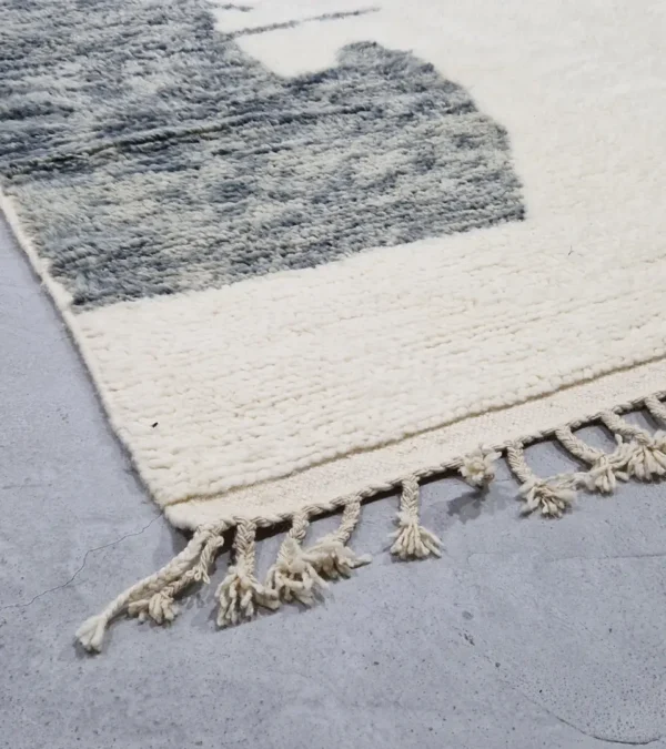 detauled view of Hand-knotted Moroccan wool rug with abstract color-block design in yellow, charcoal, and terracotta on a cream background