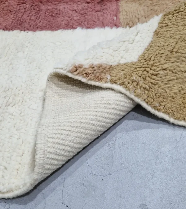 detailed view of Mauve Accent Abstract Moroccan Rug with camel, off-white, and mauve color blocks