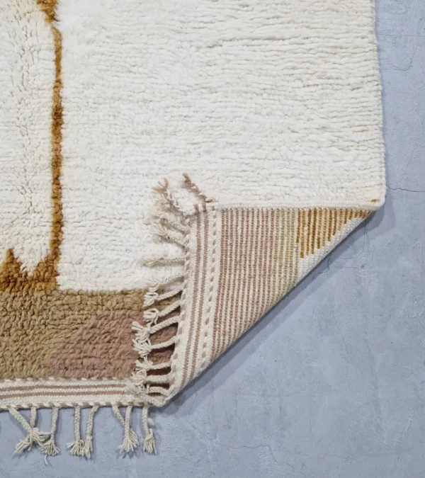 detailed view of Mauve Accent Abstract Moroccan Rug with camel, off-white, and mauve color blocks