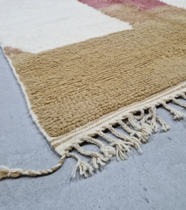 detailed view of Mauve Accent Abstract Moroccan Rug with camel, off-white, and mauve color blocks