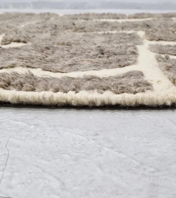 zoomed in view of Neutral modern geometric wool rug with muted brown and cream high-low pile design