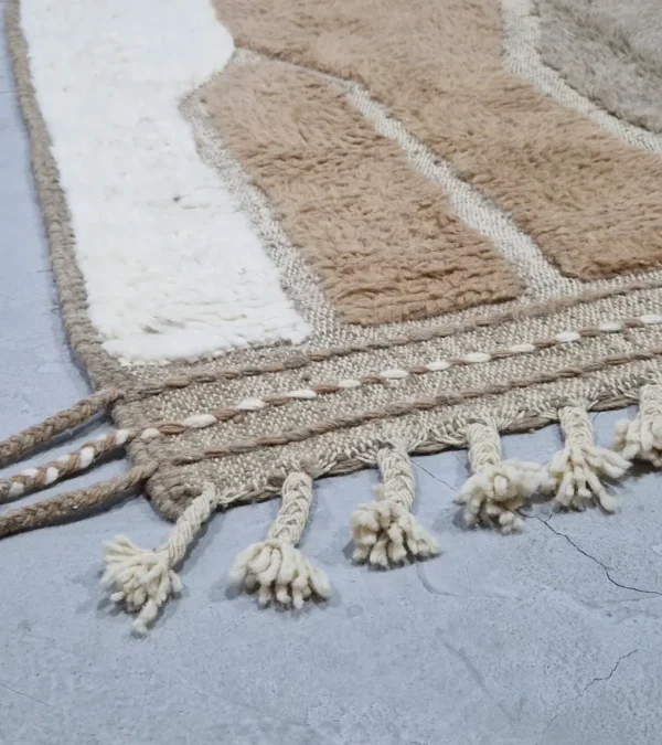 detailed view of Handcrafted Moroccan rug with sculpted high-low abstract neutral design and tassels