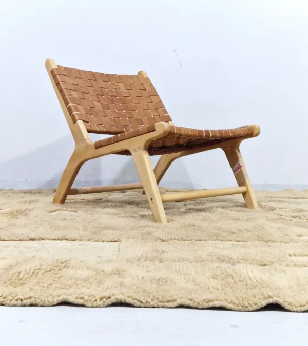Handmade Moroccan wool rug in sandy beige with sculpted off-white linework and tassels in room