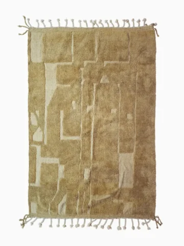 top view of Handmade Moroccan wool rug in sandy beige with sculpted off-white linework and tassels