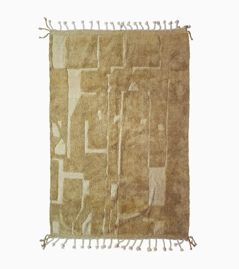 top view of Handmade Moroccan wool rug in sandy beige with sculpted off-white linework and tassels