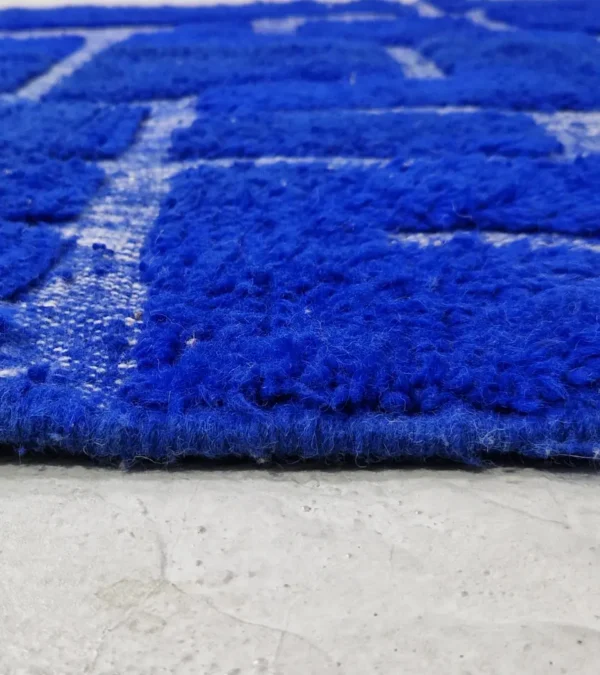 zoomed in view of Handmade Moroccan rug with bold blue base and sculpted geometric grid