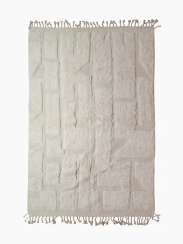 top view of Handwoven cream wool rug with sculpted high-low pile geometric pattern
