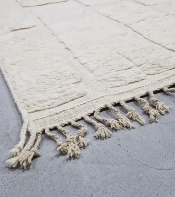 detailed view of Handwoven cream wool rug with sculpted high-low pile geometric pattern