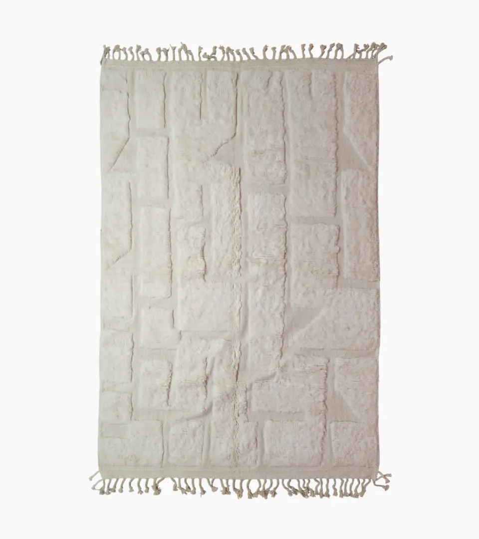 top view of Handwoven cream wool rug with sculpted high-low pile geometric pattern