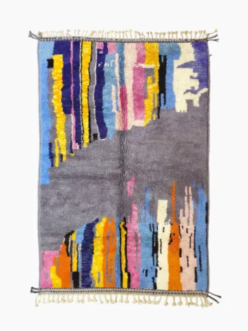 Top View of Handmade Moroccan wool rug with an abstract skyline design in multi-color on a gray background