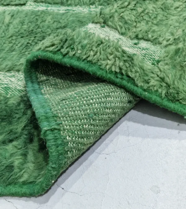 detailed view of Hand-knotted Moroccan wool rug with high-low geometric grid in green and off-white tones