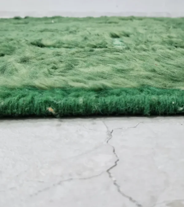 zoomed in view of Hand-knotted Moroccan wool rug with high-low geometric grid in green and off-white tones